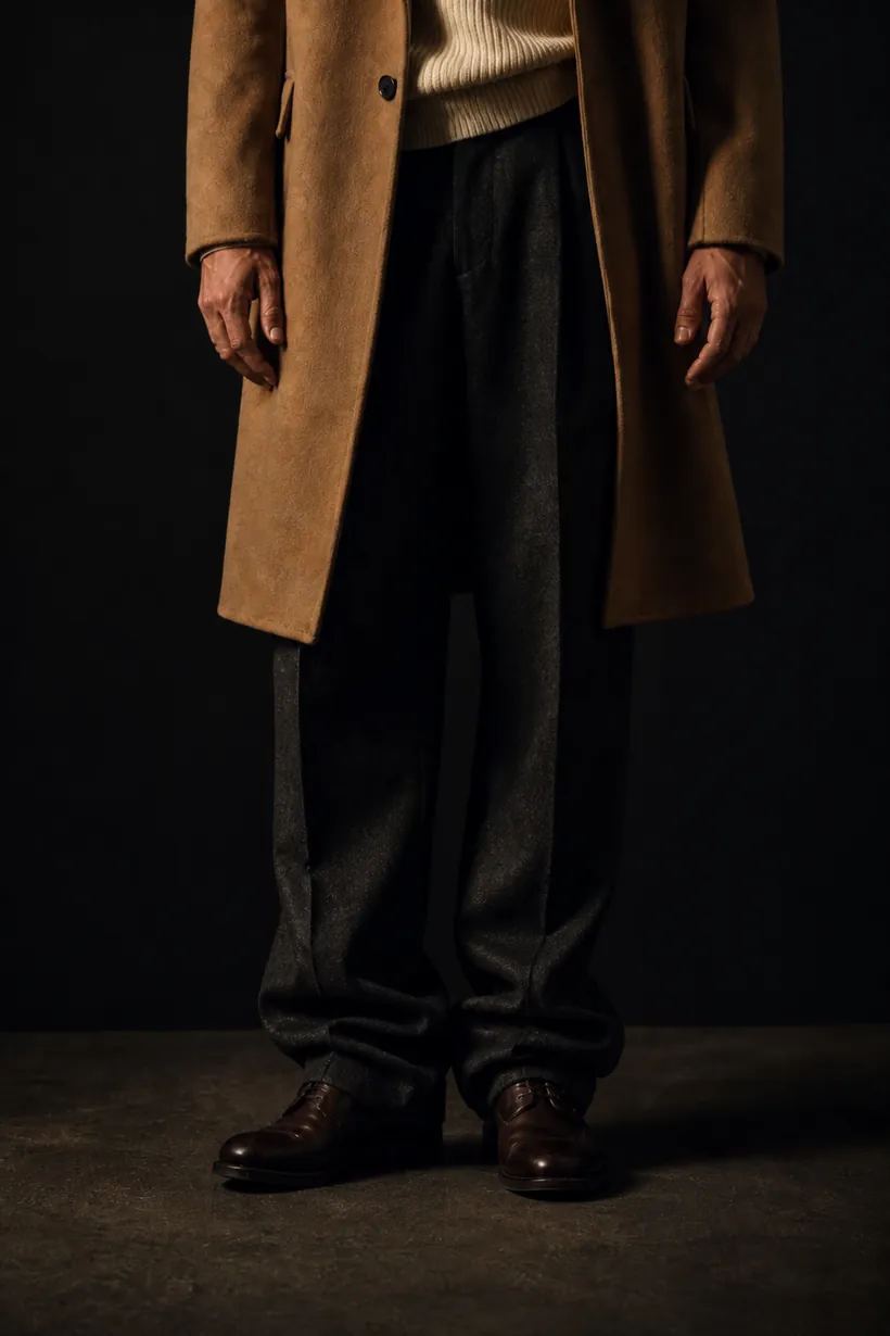 The trousers stack in folds over a brown derby shoe.